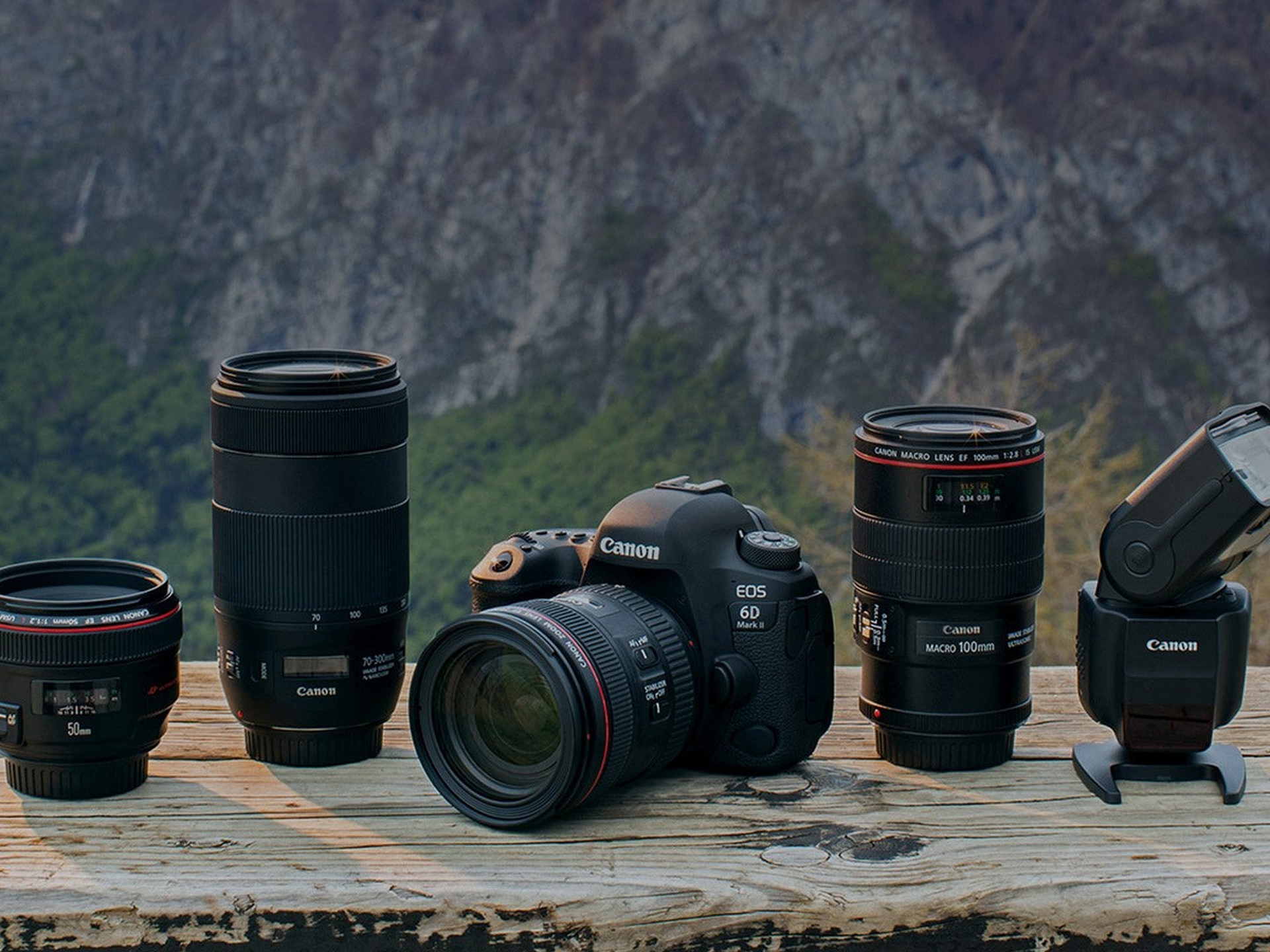 Canon range of EOS camera and lenses with a mountain background